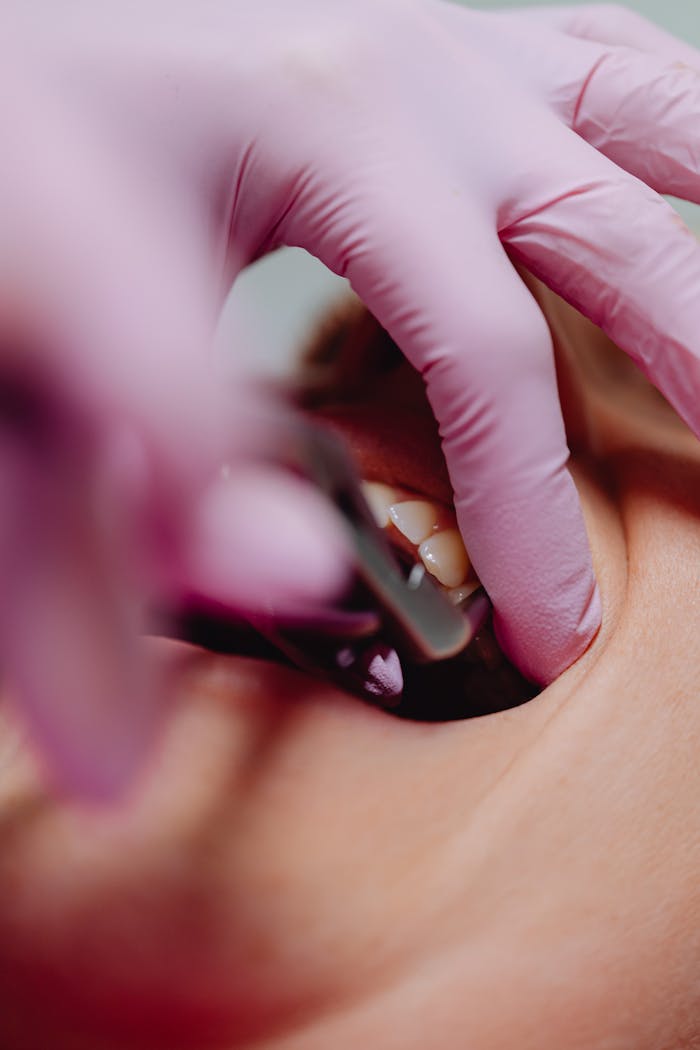 Detailed close-up of a dental check-up showing tools and a patient's mouth.